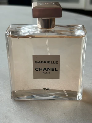 Chanel Gabrielle L'Eau Parfym 100 ml - Inköpt på Chanel i Mall of Scandinavia. Bara testad en gång då den tyvärr inte passade min dotter. Kartongen finns tyvärr inte kvar.         Stilren och modern parfym från Chanel, Gabrielle L'Eau. Perfekt för dig som vill ha en ikonisk doft med lyxig känsla. Flaskan har en elegant design och passar dig som gillar klassiska varumärken.