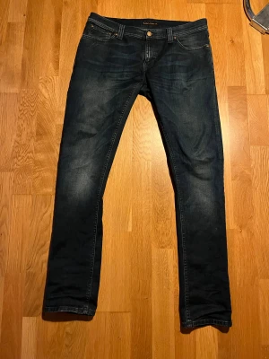 Mörkblå jeans från Nudie Jeans  - Mörkblå jeans från Nudie Jeans i strl  33,34 skulle däremot säga att de är mer åt 30,30 hållet. Jeansen har rak passform pris är diskuterbart.