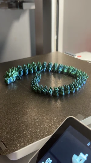 Grönblå drake 3D-printad - Unikt leksak i form av en drake, 3D-printad i skimrande grön och blå plast. Draken har detaljerade fjäll och ett coolt drakhuvud som ger en fantasy-vibe. Perfekt för dig som vill sticka ut med coolare leksaker/dekorationer som verkligen syns. För andra färger eller former är ni välkommen att meddela mig! 