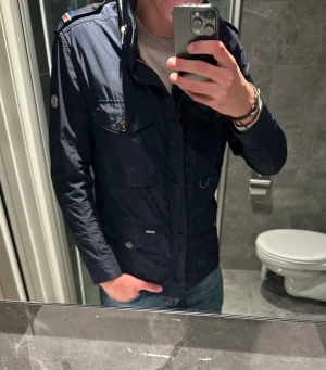 Mörkblå fieldjacket från Snoot  - Säljer en riktigt schysst field jacket från Snoot. Jackan är i riktigt bra skick men tyvärr för liten på mig. Jag på bilden är 188cm. Hör av er vid frågor:)