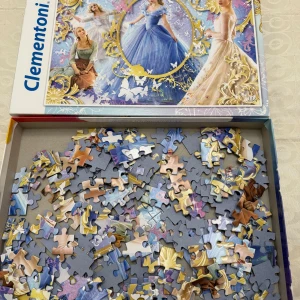 Clementoni Princess Puzzle - Färgglatt pussel med motiv av tre sagoprinsessor i vackra klänningar. Perfekt för dig som gillar Disney, fantasy och kreativa utmaningar! Pusslet är i 250 bitar och passar dig från 8 år.