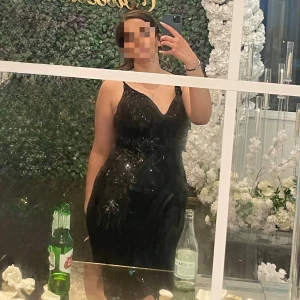 Svart glittrig långklänning med paljetter - Klänningen har v-ringad hals, smala axelband som går att justera. Perfekt för bal eller fest, med ett lyxigt och elegant uttryck. Materialet är troligtvis polyester med paljettdekoration. Jag har endast haft på mig den en gång. Passar de med storlek 40/42.