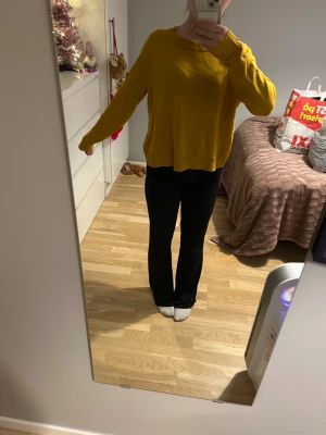 Gul stickad tröja med rund hals - Säljer en chill gul stickad tröja med rundad hals och ribbade muddar vid ärmslut och nederkant. Modellen är loose fit och har långa ärmar, perfekt för dig som gillar färg och vill ha något bekvämt och snyggt.