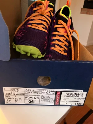 ASICS GEL-FujiRunnegade lila/gul - Säljer ett par OANVÄNDA ASICS GEL-FujiRunnegade sneakers. Skorna har grov sula för extra grepp - köptes för att springa i terräng. Inhandlades för 1199