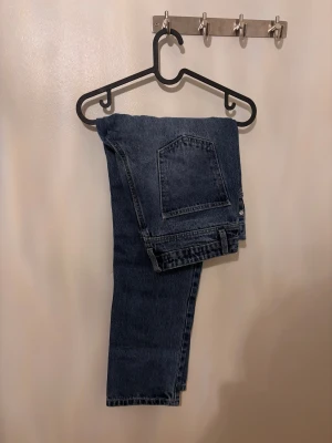 Mörkblå raka jeans - Snygga mörkblå jeans med klassisk femficksdesign och raka ben. Jeansen har en enkel look och är tillverkade i slitstarkt denimtyg. Perfekta för dig som gillar en tidlös och clean stil.