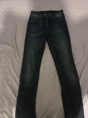 Mörkblå jeans - Snygga mörkblå jeans med skinny passform och klassisk femficksdesign. Jeansen har en lätt tvättad look och sitter tajt längs benen. Perfekta för dig som gillar en stilren och enkel look.