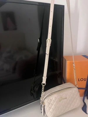 Beige axelväska från Guess - Väskan är endast använd en kväll & finns inga skador på den. 
