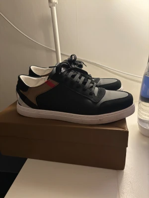 Burberry sneakers med klassiskt rutmönster - Nästan helt oanvändna burberry skor. Skick 9,9/10 kvitto finns. Använda 2 gånger på sommaren. Säljer endast för att dom är för små och inte har kommit till användning. Storlek 45
