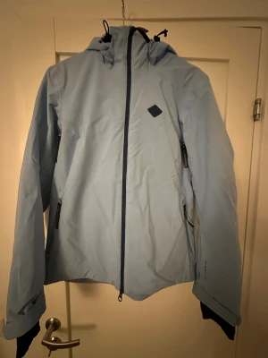 Ljusblå skidjacka från J.Lindeberg - Snygg ljusblå skidjacka från J.Lindeberg med huva och flera dragkedjor. Köpt förra året för 4000 kr. Sitter som en S/M.🌟🌟🙌🏼