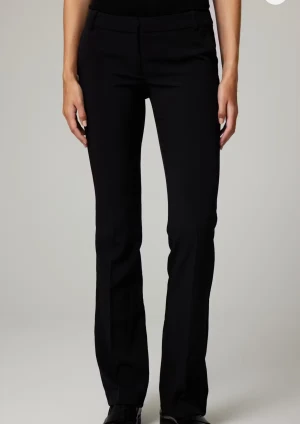 Svarta bootcut kostymbyxor - Snygga svarta kostymbyxor med bootcut-snitt och klassisk midja. Byxorna har en stilren look med pressveck och passar perfekt till en dressad outfit. Materialet är mjukt och följsamt, vilket gör dem bekväma hela dagen. Lowwaist med tall modell