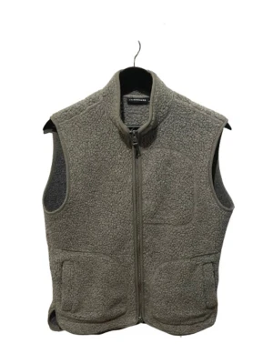 Grå fleeceväst från J.Lindeberg - Säljer en grå fleeceväst från J.Lindeberg med hög krage och hel dragkedja framtill. Västen har ett mysigt teddy-material och praktiska fickor på sidorna. Perfekt att slänga på över en t-shirt för extra värme och stil. Storlek S 