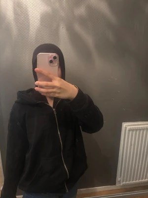 Svart hoodie med dragkedja - Svart hoodie från HM med hel dragkedja och huva. Tröjan har långa ärmar, två fickor framtill och snörning vid huvan. Materialet är mjuk bomull och passformen är loose, perfekt för chill dagar.
