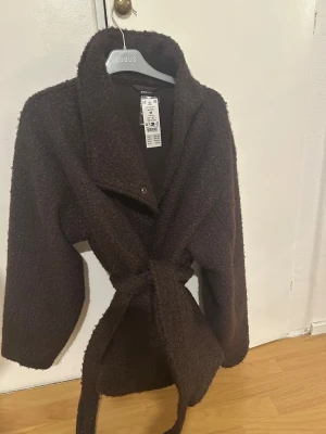 Brun Kappa från ginatricot  - Brun kappa från ginatricot som är helt oanvänd med prislappen kvar i storlek M
