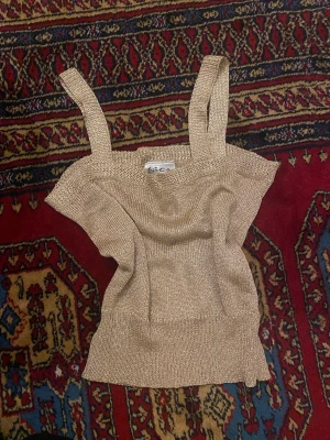 Guldig stickad topp - Säljer min guldiga stickade topp från Vico i storlek M. Men uppskattar den mer som S/XS. Den har breda axelband och är ganska kort. Jättesnygg till fest! Fråga om du vill ha bild på och var inte rädd att buda! 💓