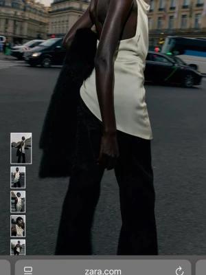 Champagnefärgad satinblus från Zara - Säljer en elegant, champagnefärgad blus från Zara i satin med draperad framsida och asymmetrisk nederkant. Ny med prislapp