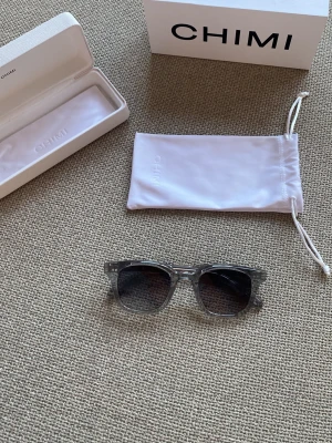 Chimi solglasögon  - Bilderna visar ett par solglasögon från CHIMI, 02 GREY som är oanvända och är i nyskick. Inga skador eller liknande, köptes för 1395kr.