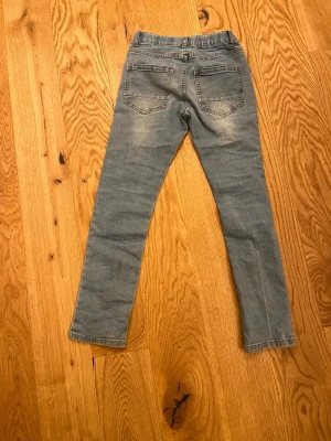 Ljusblå skinny jeans från LMTD - Snygga ljusblå skinny jeans från LMTD med klassisk femficksdesign och lätt slitna detaljer på framsidan. Jeansen har normal passform och är tillverkade i mjukt bomullsmaterial med lite stretch för extra komfort. Perfekt för dig som gillar en smal siluett.
