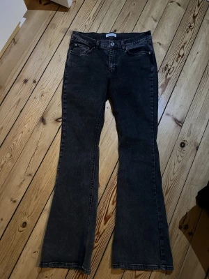 Svarta bootcut jeans - Snygga svarta jeans med bootcut-snitt och klassisk femficksdesign. Jeansen har en mörk tvätt och raka ben som breddas nedtill. Perfekta för dig som gillar en retro vibe och vill ha ett par jeans som sticker ut lite extra. Använda max 2 gånger 