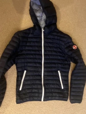Colmar jacka - Säljer nu min asfeta colmar jacka. Jackan har använts mycket och om man tittar noggrant kan man se några små hål i dunen, men inget som syns annars samt är det också väldigt enkelt att laga. Jackan är i en blå färg och storleken är 44. Nypris: 5000. Mitt pris: 1499. Hör av dig vid minsta fundering.
