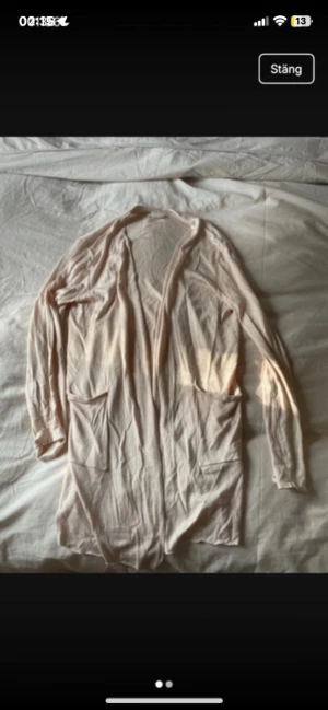 Ljusbeige kofta från H&M XS - Säljer en tunn och mjuk ljusbeige kofta från H&M i storlek XS. Koftan har långa ärmar, två framfickor och öppen front utan knappar. Perfekt att slänga över en t-shirt eller linne när det är lite kyligt ute.