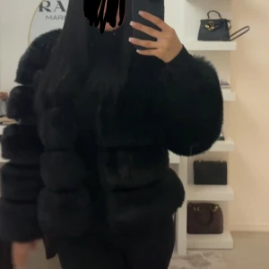 Svart fluffig pälsjacka - Fuskpälskappa köpt utomlands, den ser väldigt fluffig och lyxig ut. Oversized passar perfekt till båda vinter och sommar beroende på hur man klär den. 