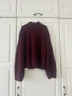 Vinröd stickad tröja från H&M❤️❤️ - Säljer en vinröd stickad tröja från H&M i storlek M. Tröjan har en hög hals, ribbad struktur och långa ärmar. Modellen är loose fit och passar perfekt för kyliga dagar. Snygg att styla med jeans eller kjol.