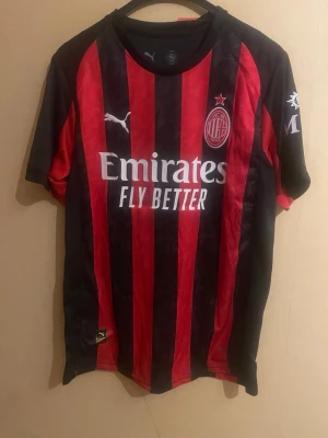 AC Milan 25/26 tröja Rafael Leão - AC Milan 25/26-kit med Rafael Leão. Tröjan är i storlek M och har den klassiska Milan-designen med klubbemblem och sponsortryck. Ett modernt och stilrent matchkit som passar perfekt för både match, vardag eller samling. Mycket fint skick. Perfekt för AC Milan-fans och Leão-supporters