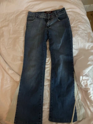 lågmidjade bootcut jeans - lågmidjade bootcut jeans med vit slits på sidorna, passar någon som är ungefär 160, skickar ej med bild på