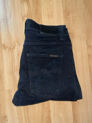 Nudie Jeans Grim Tim  - Säljer ett par jeans från Nudie Jeans i modellen Grim Tim. Midja 38cm, längd 100cm. JAG SKICKAR EJ FLER BILDER NÄR JAG BÄR JEANSEN! för bättre inblick i passformen rekommenderar jag att googla på modellnamnet. För storleksguide kolla måtten noggrant då jeansen alltid kan vara uppsydda heller krympta och jag ej tar emot returer :) s5,4