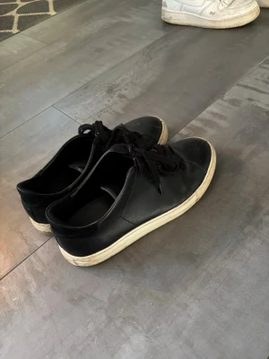 Axel Arigato sneakers – svarta, stl 40 | Fynd! - Säljer ett par svarta Axel Arigato-sneakers i storlek 40. Skorna är välanvända, men fortfarande fullt användbara och perfekta som vardagsskor. Bekväma och lätta att matcha!Nypris: ca 2000 kr.  Pris: endast 299 kr – riktigt bra deal för ett par Arigato!  Perfekt för dig som vill ha ett par schyssta märkes­sneakers till ett lågt pris. Hör av dig vid intresse!