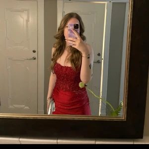 Vinröd balklänning  - En super vacker röd balklänning med stenar och spets! Den är i storlek S. Den har en djup öppen rygg med band i kors! Köpte den på Vinted och den är använd en natt av mig och av förra ägaren! Den är köpt originellt från Zapaka! 