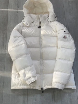 Vit pufferjacka från Moncler - Säljer en clean och fluffig vit pufferjacka från Moncler med huva och logga armen. Storlek S modellen är unisex, NFC fungerar och jackan är i fint skick! Pris går att diskutera