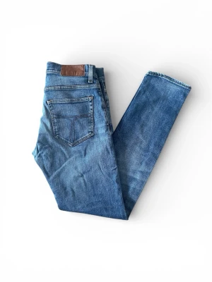 Blå Tiger of Sweden Pistolero jeans W29 L32 - Jag säljer dom här blå Tiger of Sweden jeansen som är i modellen Pistolero. Storleken är W29 L32. De är fint skick utan skador. Tveka inte att höra av er!                                                                  Mått: Längd=104cm. Midja=38cm