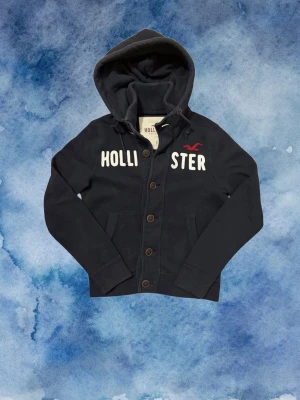 Vintage Hollister Cardigan Med Knappar - Säljer denna as feta och sällsynta Hollister cardigan med knappar, mycket eftertraktad! | Mycket bra skick | Storlek S | Längd ≈ 62cm, Bredd armhåla - armhåla ≈50cm | Model 175cm, 68kg | Pris kan diskuteras 