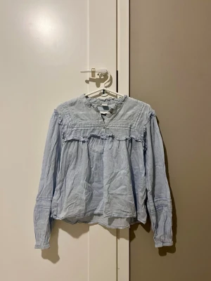Ljusblå blus från Lindex - Jag säljer denna ljusblåa blus med detaljer! Den är barnstorlek, storlek 164. Men passar åndå mig som är xs. Jag kommer även stryka den efter den blir köpt!