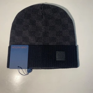 LVmössa - Svart mössa med clean och stilren design. Perfekt för streetwear och vardagsoutfits. Bekväm passform. One size. Bra skick. Fraktar direkt efter köp. Pris kan diskuteras.Längd 110cm 