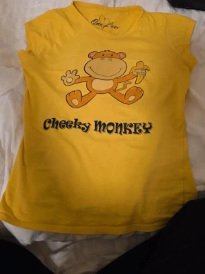 Gul Cheeky Monkey t-shirt One Love - Gul t-shirt från One Love i storlek S, men upplevs mer som XS.  Den är vintage. Det står 'Cheeky Monkey' på framsidan. Kolla noggrant på bilderna, då jag inte gör returer!                                                      Priset kan diskuteras 💕🐵💫, skriv till mig om du har frågor!