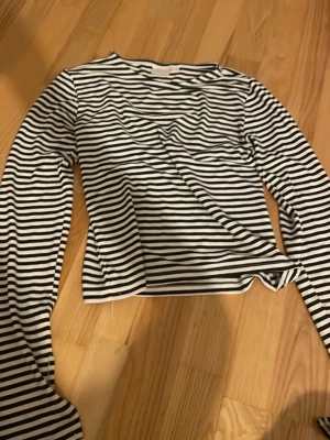 Randig långärmad topp från Gina Tricot - Säljer en svartvit randig långärmad topp från Gina Tricot i storlek 158/164. Toppen har klassiska horisontella ränder och är gjord i mjuk bomull. Perfekt för dig som gillar enkel och stilren design. Enkel att matcha till jeans eller en kjol. Bra skick och inte använd mycket 