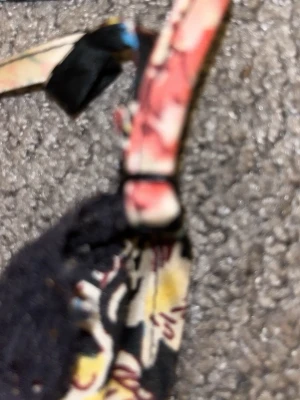 Blommig linnetopp med spetskant - Säljer en färgglad linnetopp med blommigt mönster i rosa, blått, gult och vitt på svart botten. Toppen har tunna axelband och en snygg spetskant vid halsen. Materialet känns lätt och mjukt, perfekt för varma dagar.