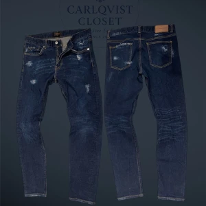 J.Lindeberg Jay slim fit jeans blå - Säljer ett par schysstare J.lindeberg jeans med vintage look samt egnagjorda slitningar || Det står 33/32 men är mer som 30/32 (se mått) || Midja 39cm, längd 98cm, innerben 73cm || Hör av er vid minsta fråga, svara snabbt!!💫