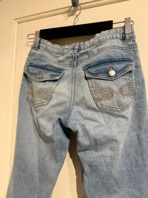 Blå bootcut jeans  - Låg midja och broderade fickor. Längden är bra på någon som är typ 160-165. 164 är typ xs