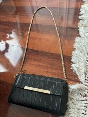 Svart axelväska  - Snygg svart axelväska. Kedjan är sönder därav priset annars är den jätte fin och ser lyxig ut.