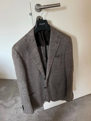 Brun kavaj från Corneliani - Säljer en stilren brun kavaj från Corneliani, tillverkad i Italien. Kavajen har klassisk passform, två knappar framtill och diskreta fickor. Materialet är ull och insidan är fodrad med mörkt tyg. Perfekt för dig som vill ha en snygg och tidlös look. Ny pris ca 14000kr