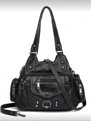 Svart axelväska med dragkedjor - Cool svart vintage axelväska i skinnimitation med flera dragkedjor och fickor framtill och på sidorna. Väskan har både handtag och en avtagbar axelrem, samt snygga nitar och spänne som detaljer. Perfekt för dig som vill ha plats för allt! Många bra fack! I mycket bra skick