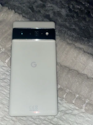 Google Pixel 6a pro ( krypterad  inga skador - Snygg Google Pixel 6 i vitt, med unik kameradesign och stor skärm. Telefonen är i gott skick utan synliga repor eller skador. Perfekt för dig som vill ha en kraftfull Android-telefon med utmärkt kamera och modern design.