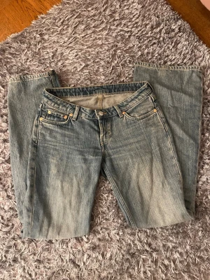 Lågmindjade weekday jeans  - Säljer ett par jeans från weekday i blå tvätt med bootcut-snitt. De har fem fickor, knapp och dragkedja fram. Jeansen är gjorda i slitstarkt denim och har en snygg, lite blekt look. 