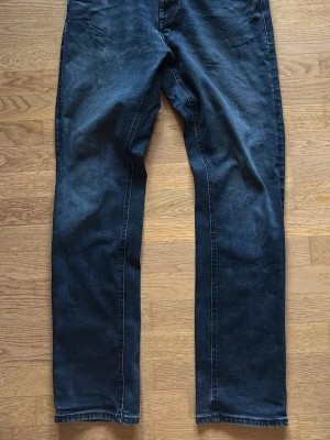 Slim fit jeans från Massimo Dutti - Snygga mörkblå slim fit jeans från Massimo Dutti med klassisk femficksdesign och knappstängning. Jeansen har raka ben och är tillverkade i mjukt bomullsmaterial med lite stretch för extra komfort. Perfekt för dig som gillar stilrena och moderna jeans. Passar dig som har storlek 31/32 i jeans