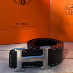 H Bälte Svart - Säljer ett svart bälte med ett silvrigt snyggt ”H” spänne. Bältet har en längd på 105 cm (storlek 42) och är Inte använt en enda gång, tveka inte att fråga! 💯👌 