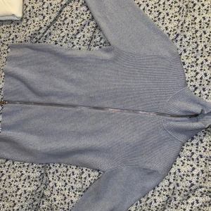 Ljung-Ljusblå Ribbad Helzip. Använd 2 ggr. Nypris:1500kr - Säljer en ljusblå ribbstickad kofta från Ljung by Marcus Larsson i storlek L. Koftan har hel dragkedja framtill, hög krage och långa ärmar. Perfekt för lager-på-lager och chill stil. Superenkel att matcha med jeans eller chinos. Nypris:1500