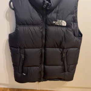 Svart dunväst från The North Face -  Använd få gånger, jätte bra skick, storlek Junior Xl. Jag är 178cm lång och har vanligvis S i jackor